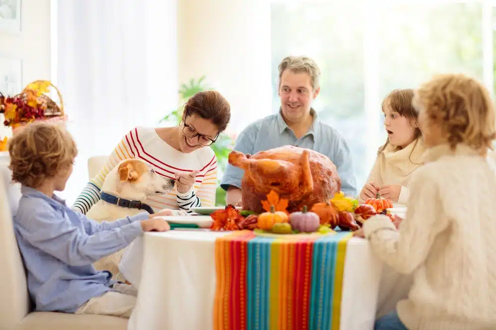 family with a dog by the dinner table