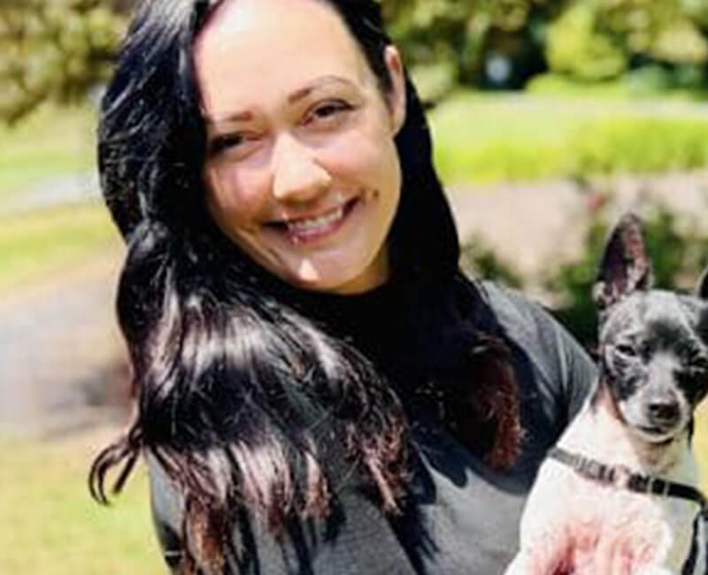 Vet doing a wellness exam on a little dog.